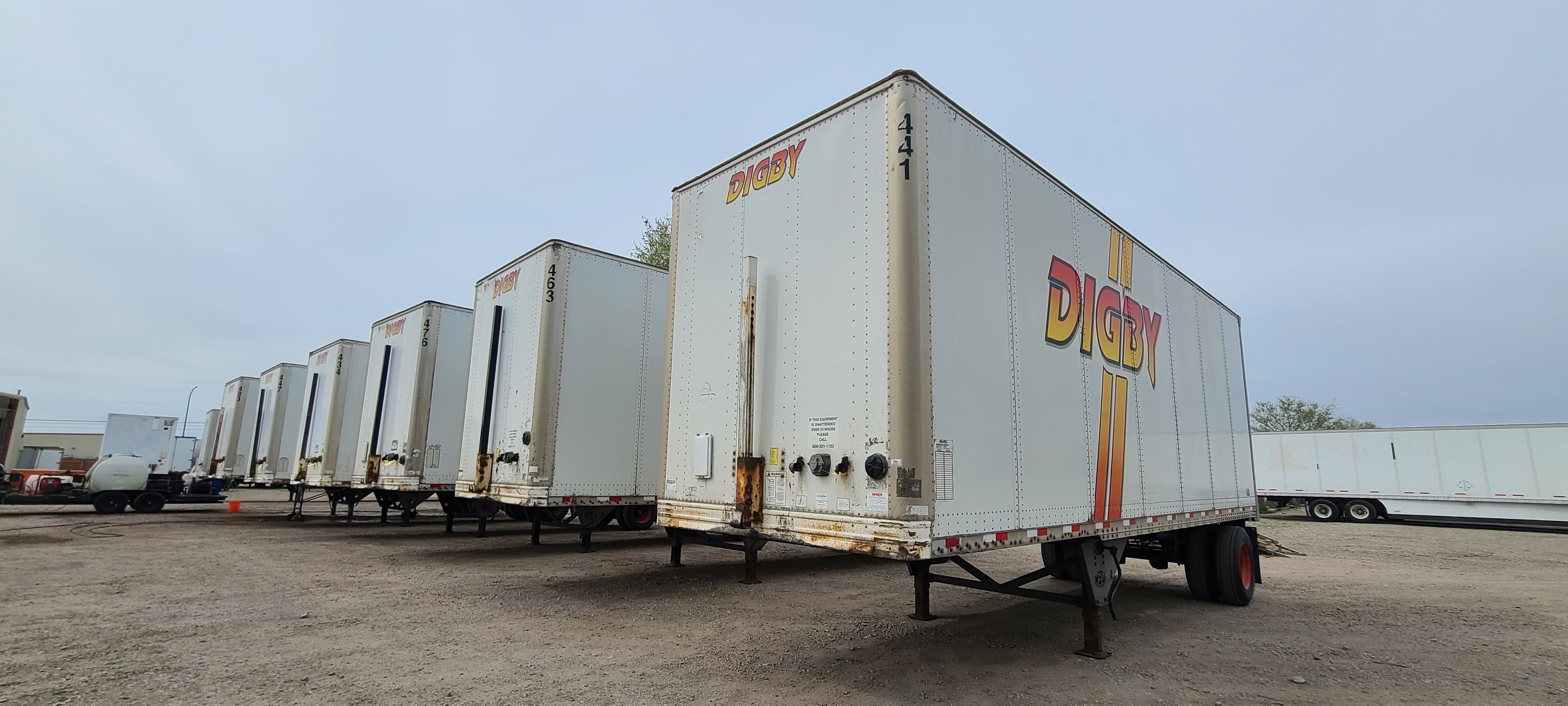 Digby commercial trailers lined up before fleet de-identification — multiple semi trailers awaiting decal removal and restoration