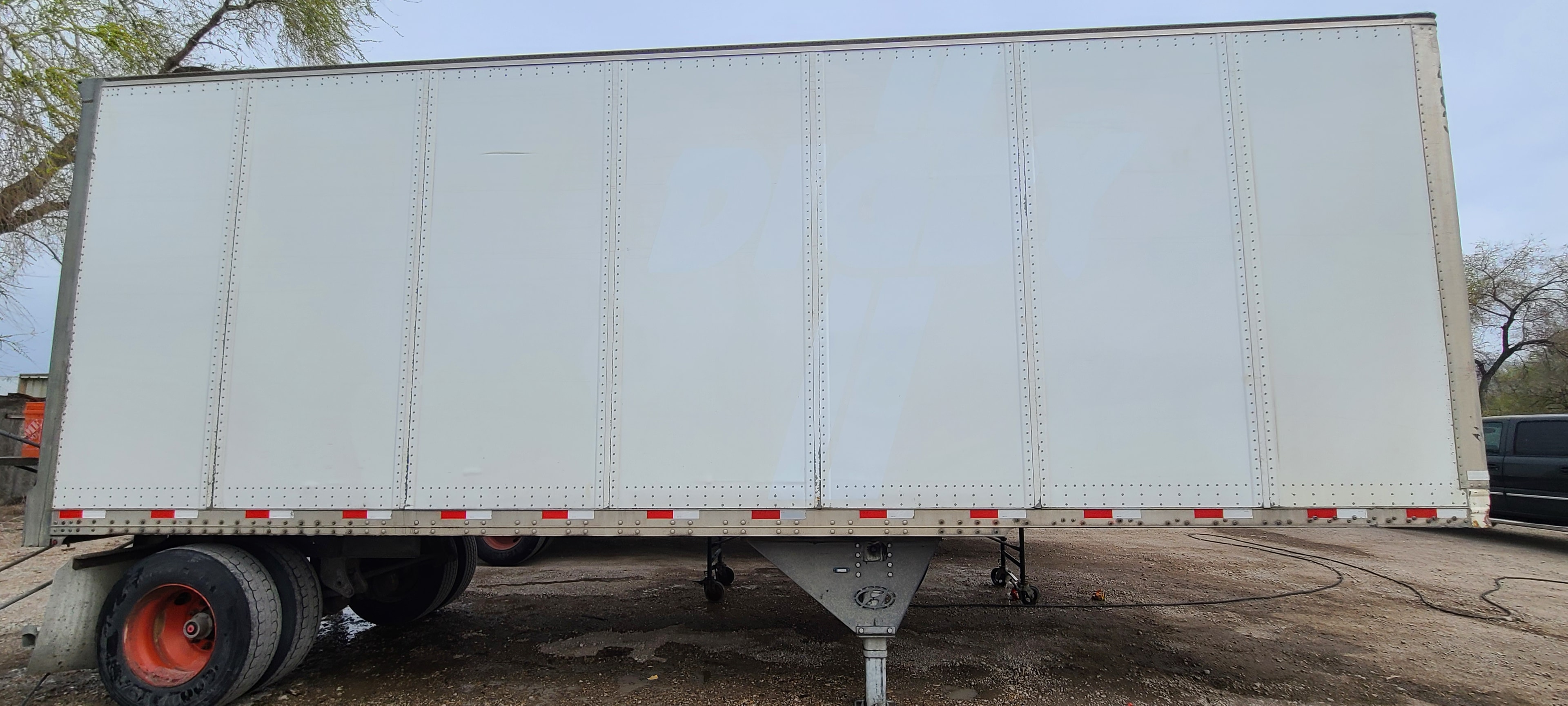 Commercial trailer side panel fully stripped of fleet decals during professional de-identification — clean aluminum surface ready for pressure washing in Utah