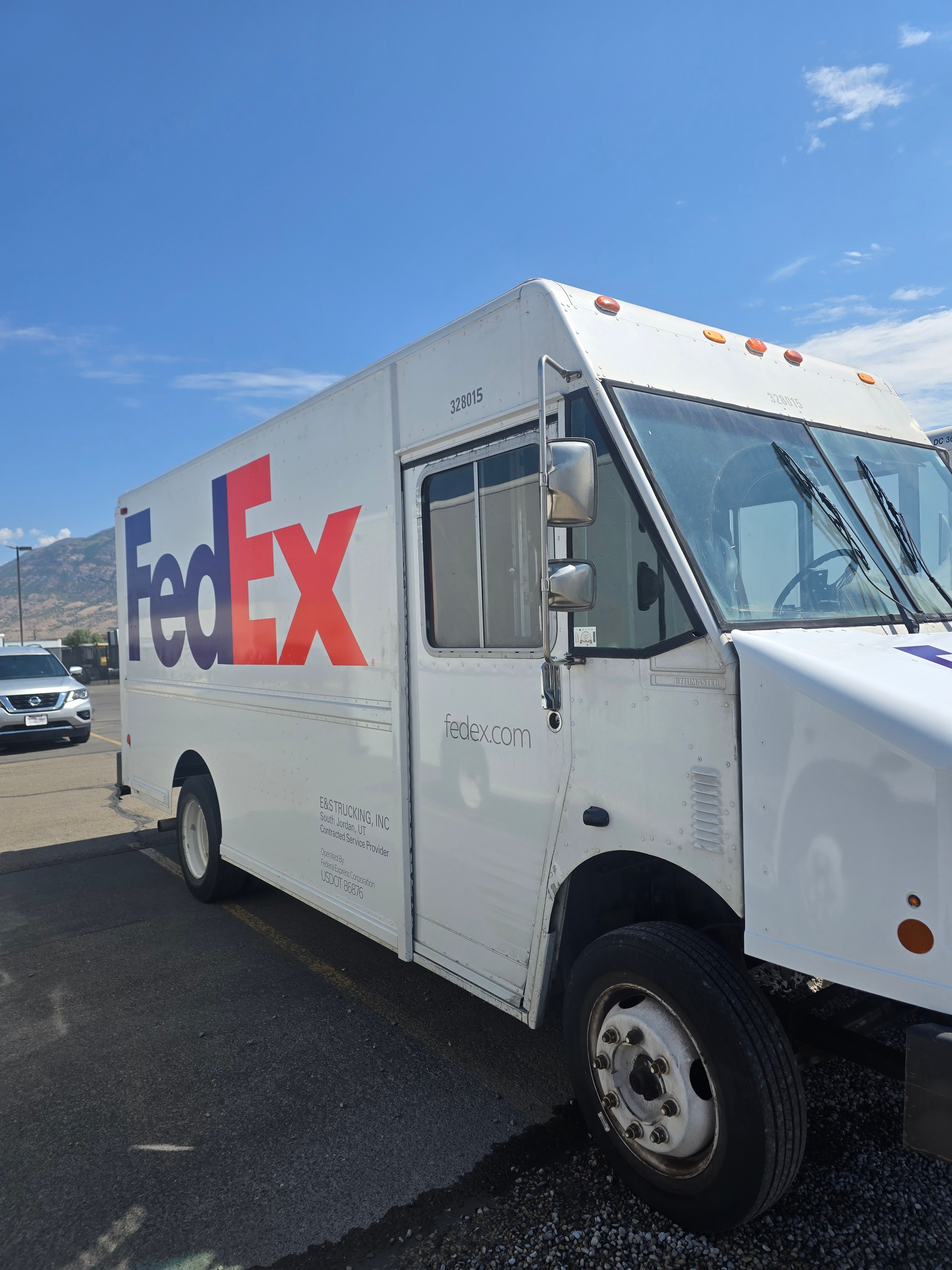 FedEx step van driver side after decal removal — door open, side panel clean after Utah fleet rebranding