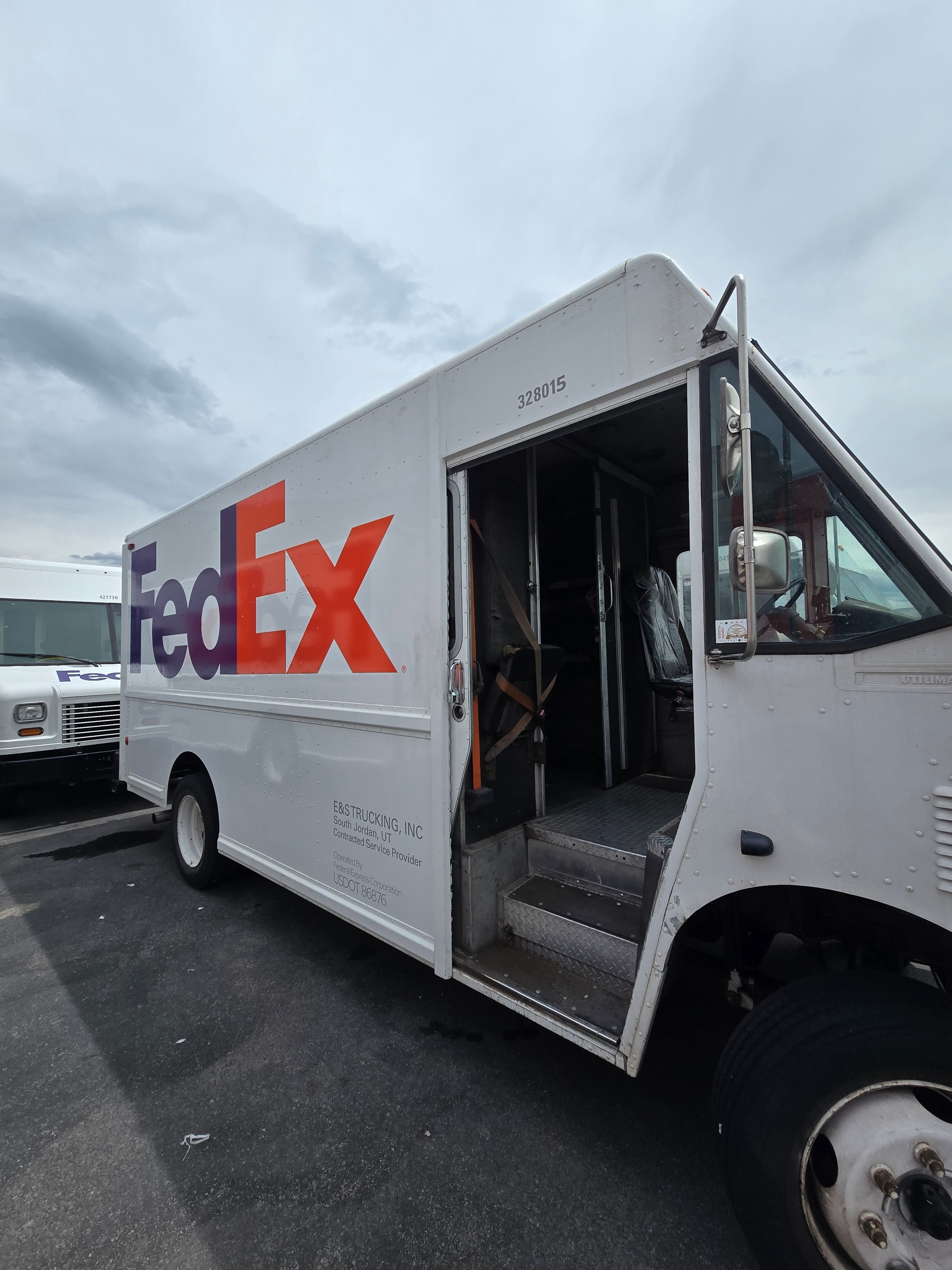 FedEx step van cab open after decal removal — driver compartment and side panel after Utah fleet de-identification