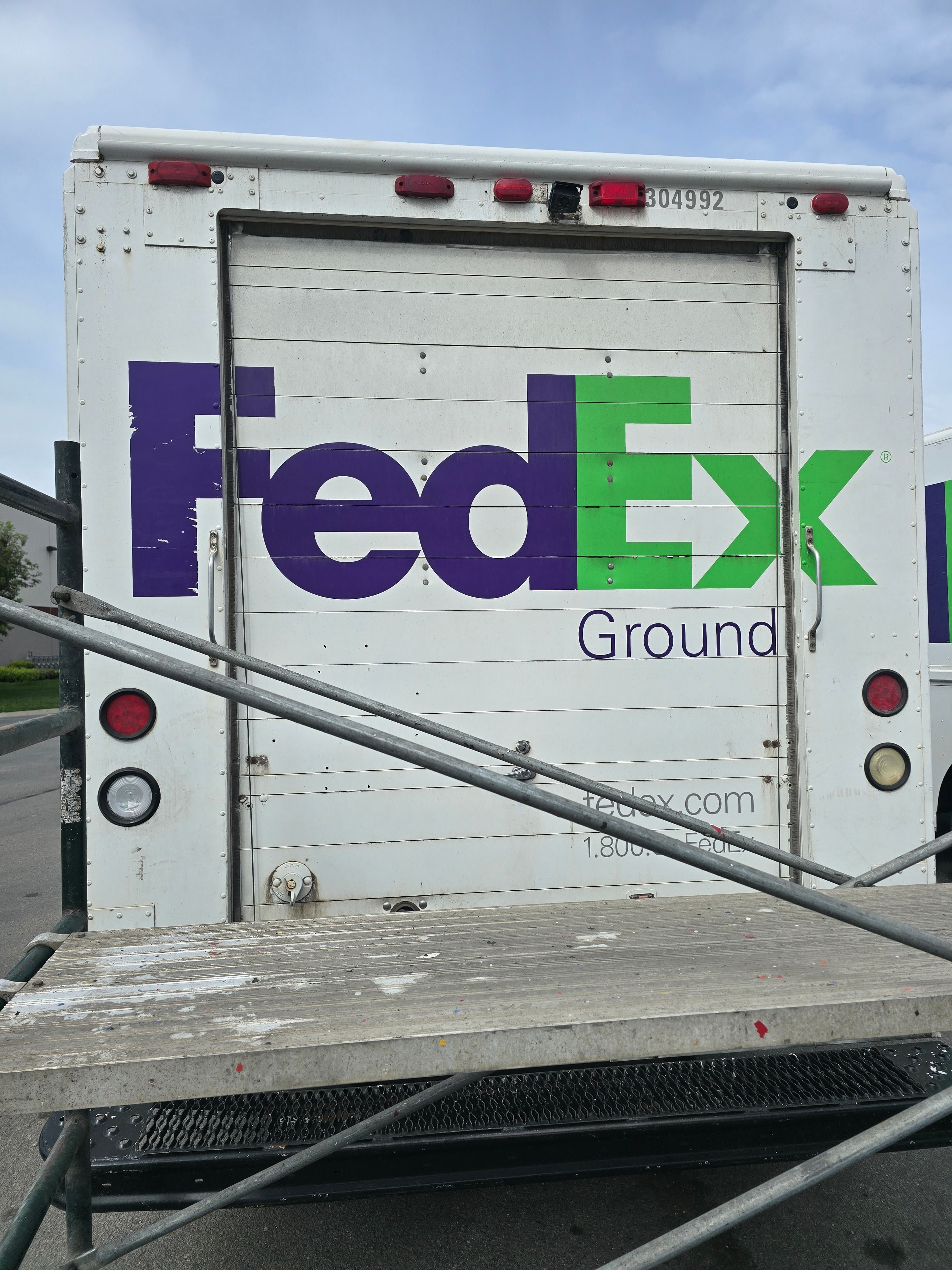 FedEx Ground step van rear door — FedEx Ground logo and contact decals before professional removal