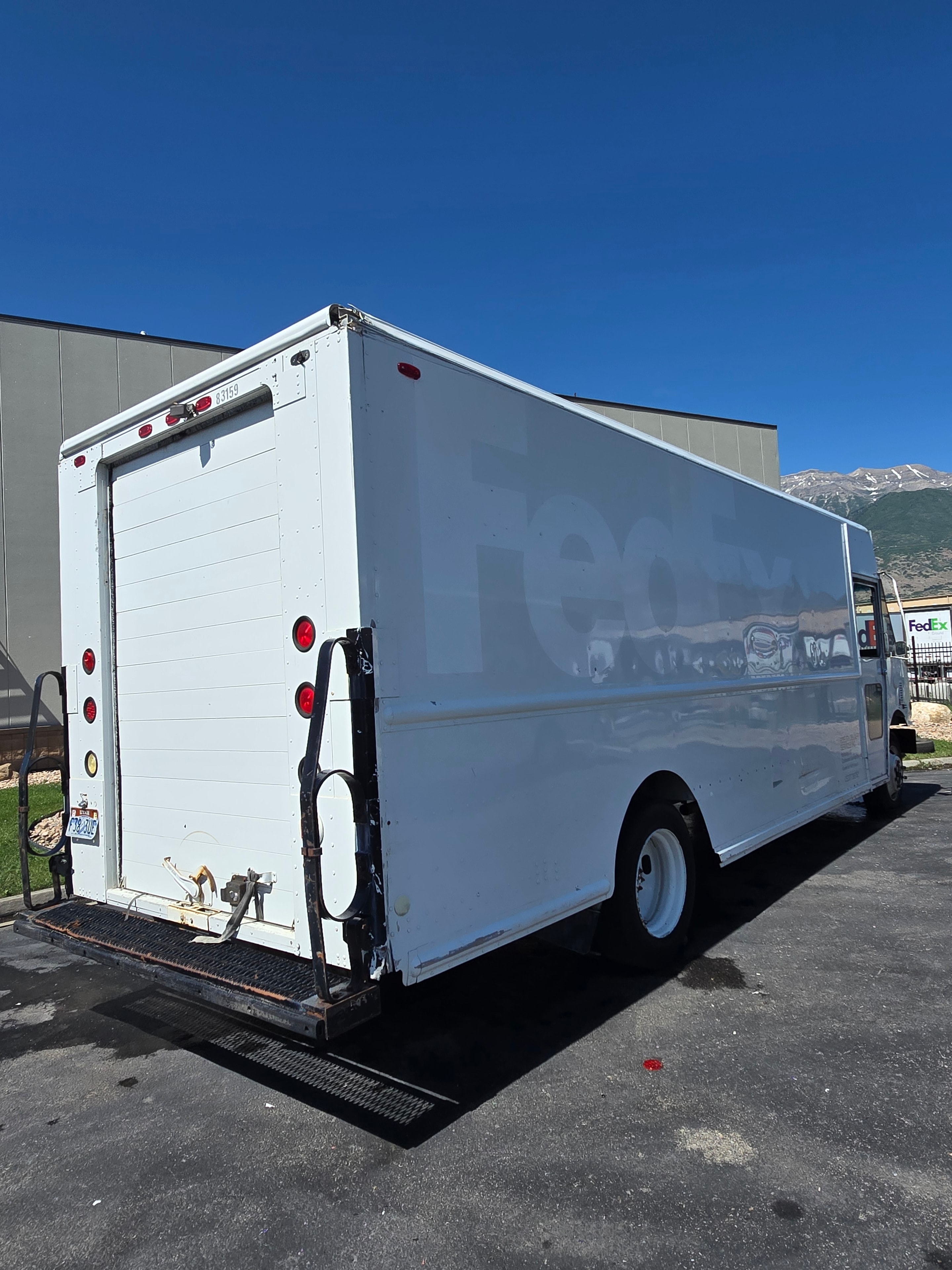 FedEx Ground step van USDOT 265752 — side panel closeup showing adhesive ghosting after decal removal during fleet rebranding