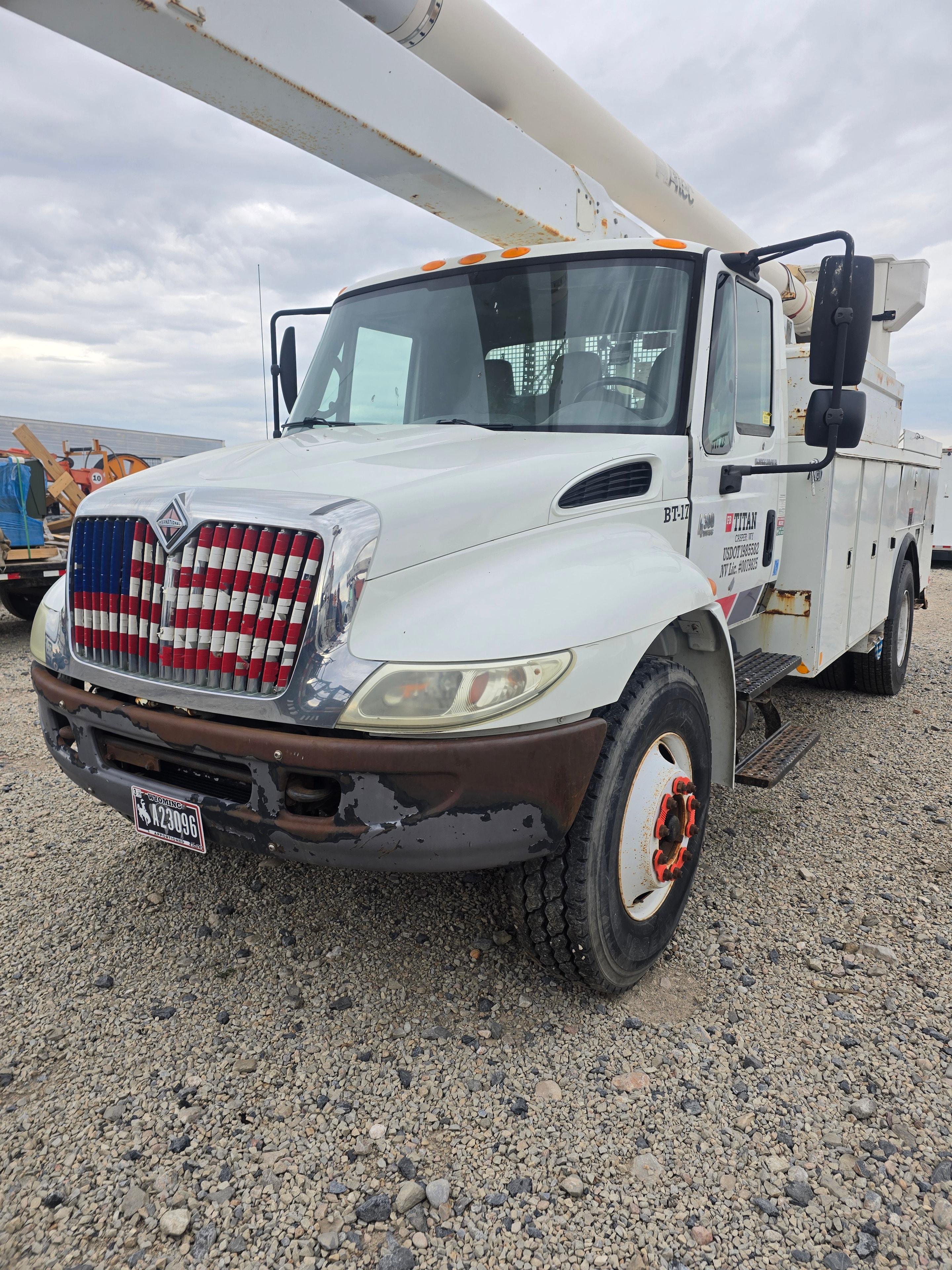 Titan International bucket truck BT16 cab front before washing — road film and rust accumulation