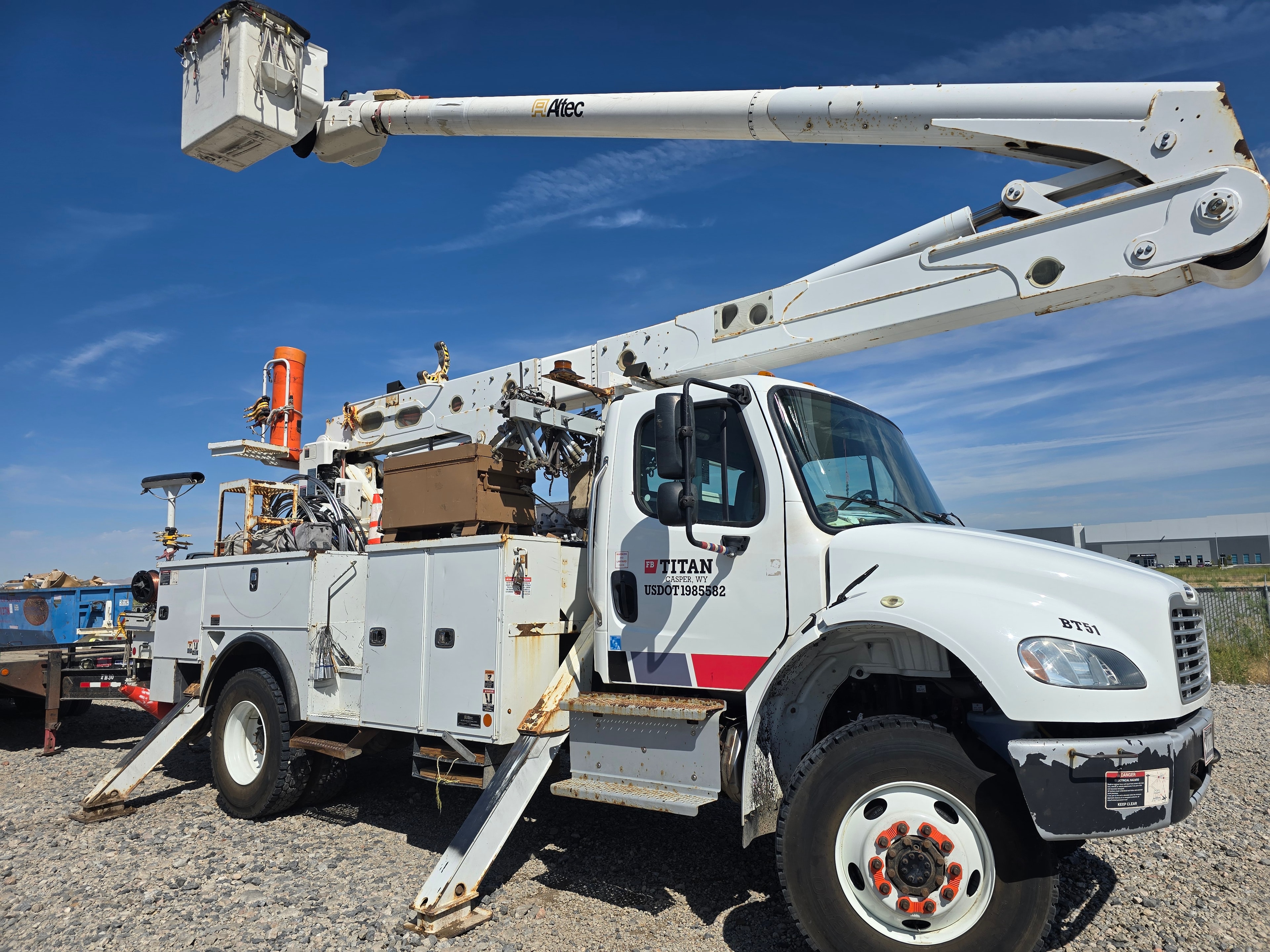Titan Freightliner bucket truck BT51 with Altec boom side view before washing — road grime and rust buildup
