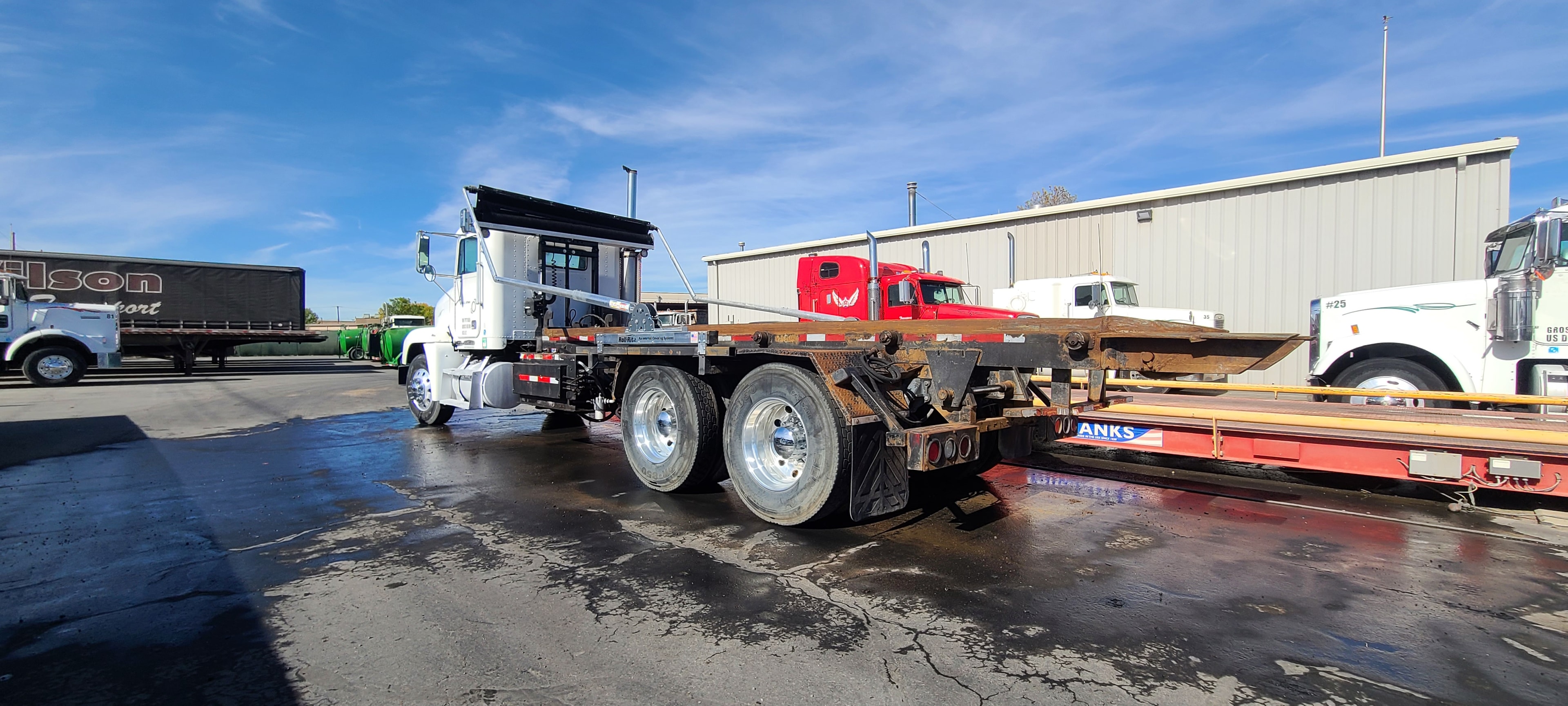 White cabover with Roll-Rite flatbed — full yard transformation after washing, Wilson Transport Salt Lake City